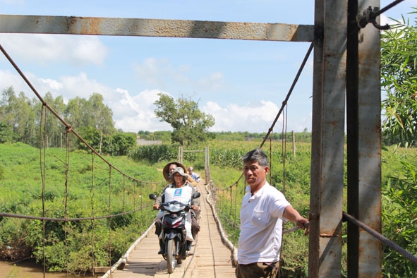 Ông Lê Kim Quynh  bên cây cầu.