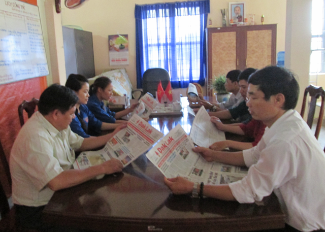 Cán bộ, nhân viên UBND xã Hòa Hiệp (huyện Cư Kuin)  đọc báo đầu giờ làm việc. Ảnh: Hồng Khanh
