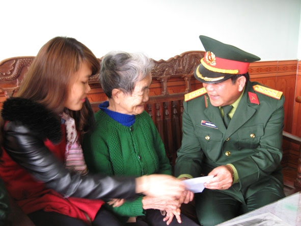 Đại diện lãnh đạo Bộ Chỉ huy Quân sự tỉnh trao quà tặng bà Bùi Thị Sành là mẹ của liệt sĩ Nguyễn Thành Trung.   Ảnh:  Phan Diệm