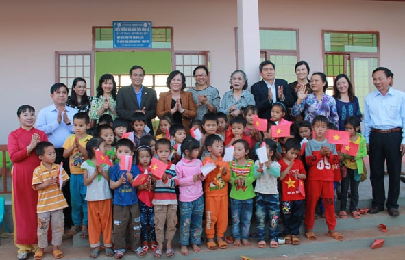 Lãnh đạo các bộ, ngành, địa phương với các em học sinh trong ngày bàn giao  điểm trường mẫu giáo thôn Bình Lợi.