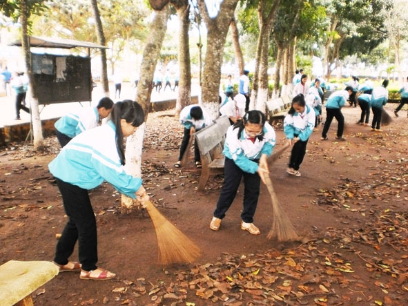 Học sinh tham gia vệ sinh sân trường tạo cảnh quan xanh - sạch - đẹp.