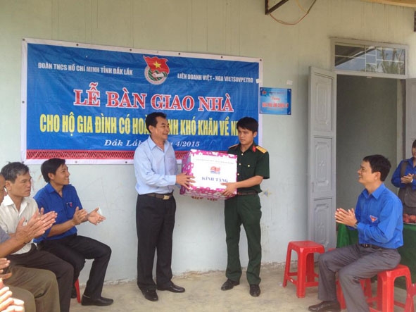 Đại diện Công ty Liên doanh Dầu khí Việt – Nga VietsovPetro tặng quà cho Thượng úy Trần Văn Kiều  trước ngôi nhà mới xây dựng.