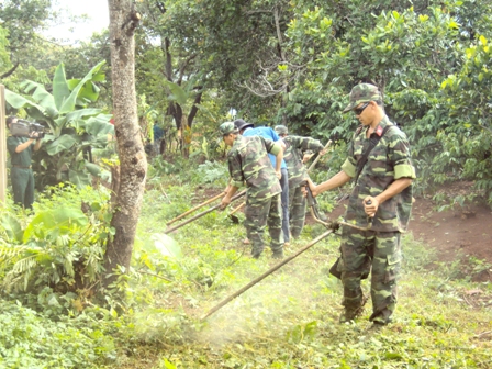 Cán bộ, chiến sĩ Ban Chỉ huy Quân sự thành phố giúp dân làm đường giao thông nông thôn tại buôn Kdun (xã Cư Êbur).