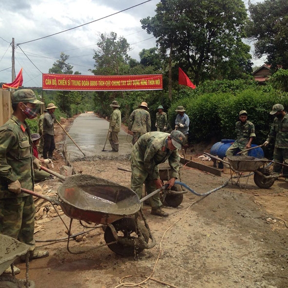 Chiến sĩ Trung đoàn Bộ binh 95  giúp bà con làm đường giao thông  tại buôn Tung, xã Ea Drông.