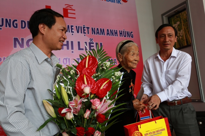 Lãnh đạo địa phương và ngân hàng tặng hoa cho mẹ Ngô Thị Liễu