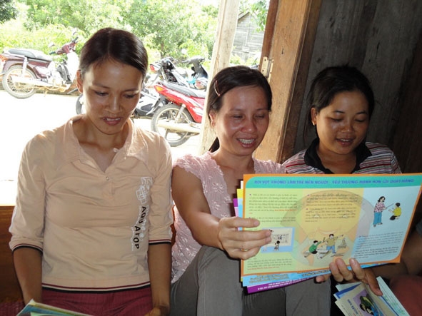 Phụ nữ thôn 8, xã Ea H’Mlay (huyện M’Đrắk) đọc tài liệu tìm hiểu kiến thức về giáo dục con.