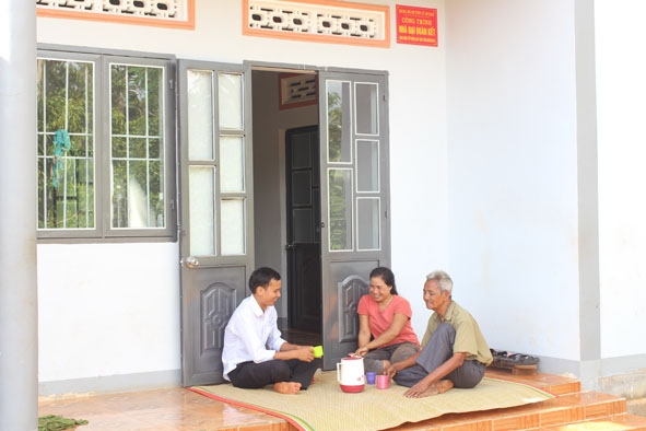 Cựu chiến binh Đinh Xuân Trụ (ngoài cùng bên phải) trò chuyện với bà con trong ngôi nhà mới.