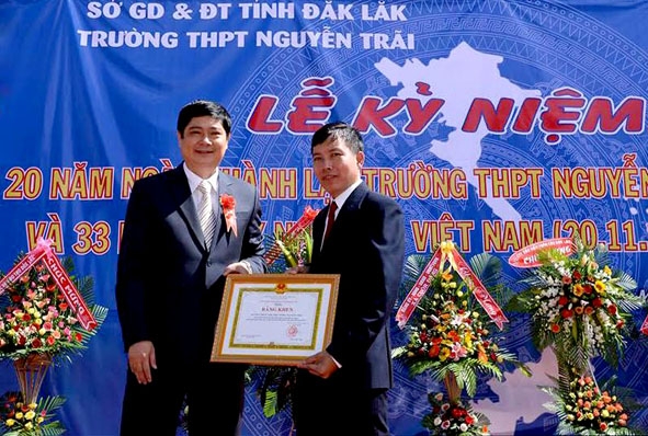Phó Giám đốc Sở Giáo dục và Đào tạo Phạm Đăng Khoa  (bên trái) trao Bằng khen của UBND tỉnh tặng  tập thể nhà trường.