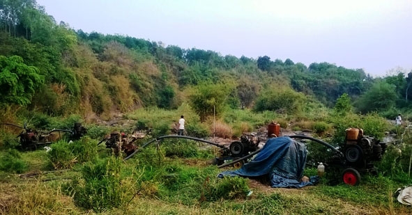 Người dân đặt máy bơm trên lòng sông Krông Năng để tìm hút nước cứu cây trồng. 