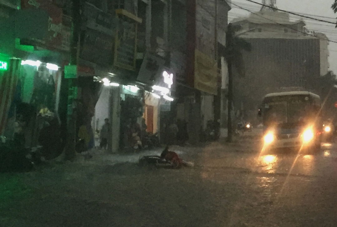 Một chiếc xe máy dựng ven đường bị nước cuốn trôi