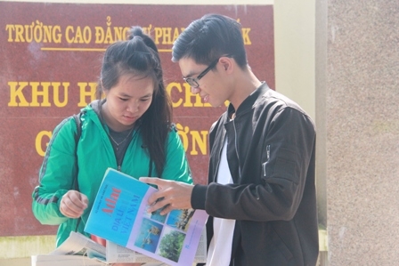 Thí sinh giở Atlat Địa lý Việt Nam để dò lại kết quả phần bài làm của mình.