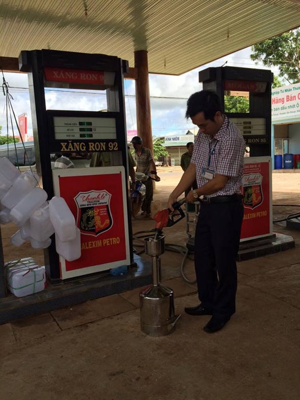Kiểm tra cột bơm xăng bằng bình chuẩn tại cửa hàng xăng dầu Ngọc Minh,  thị trấn Ea Súp, huyện Ea Súp.