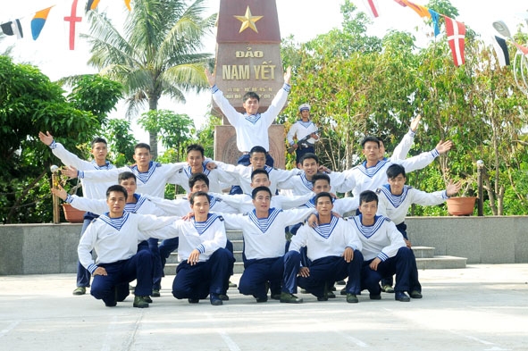 Chiến sĩ trẻ đảo Nam Yết bên cột mốc chủ quyền. Ảnh: Hoàng Chí Hùng