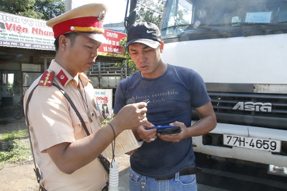 CSGT Công an tỉnh kiểm tra hành chính một tài xế xe tải trên đường Hồ Chí Minh.