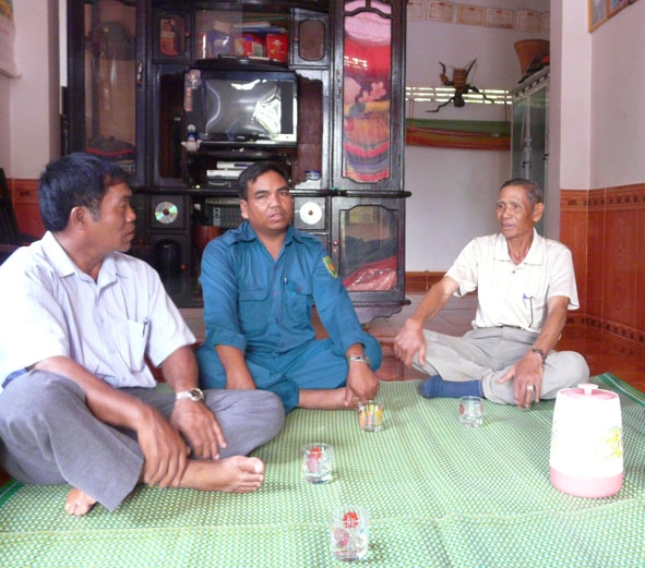 Ông Y Dhan Adrơng (bên trái ngoài cùng) đến thăm hỏi bà con trong buôn.