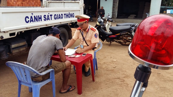 Đội CSGT – TTCĐ huyện Buôn Đôn lập biên bản vi phạm lỗi không đội mũ bảo hiểm. 