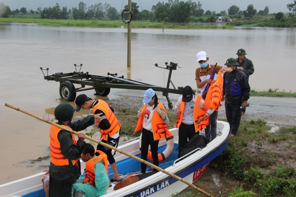 Lực lượng chức năng huyện Krông Bông dùng ca nô đưa người dân ra vào vùng bị cô lập. 