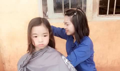 Tình nguyện viên cắt tóc cho thiếu nhi 