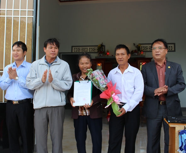 Đồng chí Đỗ Quốc Hương (thứ 2 từ trái sang) trao sổ tiết kiệm tặng gia đình chính sách ở tổ dân phố 4, thị trấn Liên Sơn.