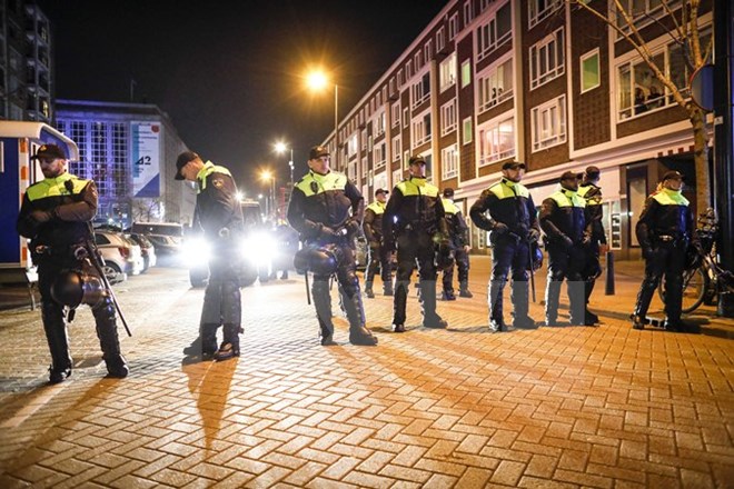 Cảnh sát gác tại một con phố khi người Thổ Nhĩ Kỳ tại Hà Lan biểu tình bên ngoài lãnh sự quán Thổ Nhĩ kỳ ở Rotterdam đòi gặp bà Fatma Betul Sayan Kaya, người đã bị cảnh sát ngăn cản tới thành phố này, ngày 11-3. (Ảnh: EPA/TTXVN)