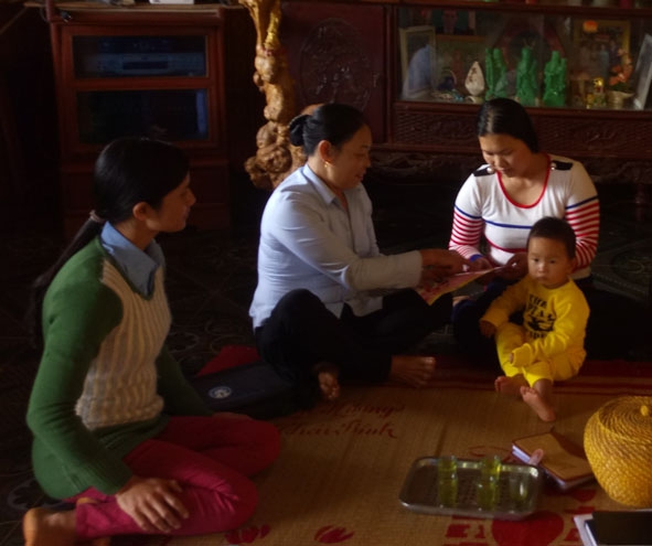 Chị Vũ Thị Hồng (giữa) đang vận động người dân thực hiện kế hoạch hóa gia đình.   Ảnh: T.Nguyên