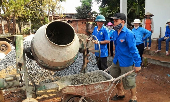 Đoàn viên thanh niên huyện Krông Búk giúp người dân làm sân bóng chuyền tại xã Pơng Đrang.    Ảnh: D. Tiến