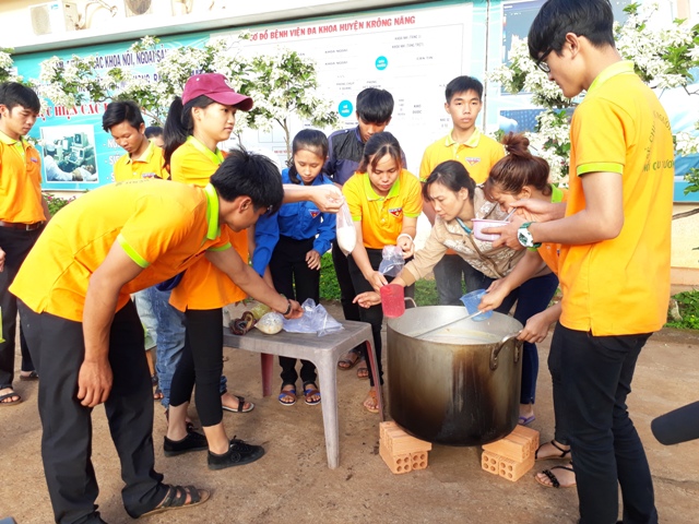 Các thành viên chương trình “Nồi cháo yêu thương” múc cháo chuẩn bị giao cho người bệnh.