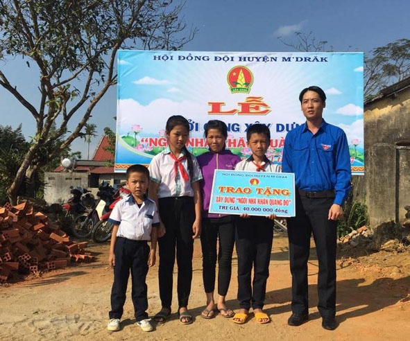 Đại diện Huyện Đoàn M’Đrắk trao biểu trưng ngôi nhà Khăn quàng đỏ tặng gia đình em Nguyễn Bùi Hồng Anh (xã Ea Riêng). 