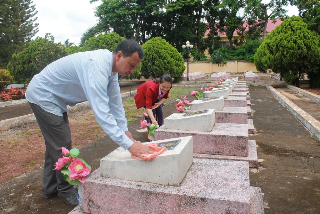 Cán bộ Phòng Lao động, thương binh và xã hội huyện Ea H'leo chăm sóc các phần mộ tại nghĩa trang liệt sỹ huyện