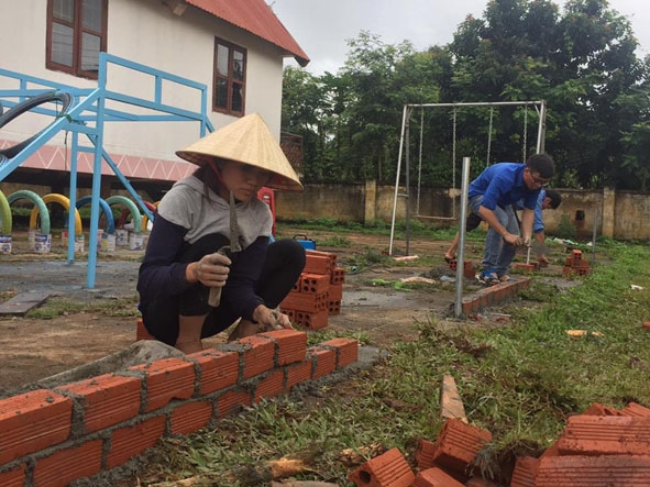 Đoàn viên, thanh niên làm sân vui chơi thiếu nhi ở buôn Tah, xã Ea Drơng.