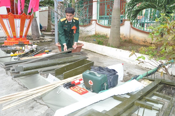 Đại úy Lê Đắc Tuấn đang kiểm tra mô hình học cụ trong luấn luyện.   