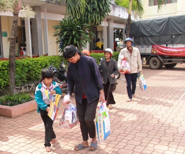 Người dân nghèo xã Cư Êbur phấn khởi khi được nhận quà.