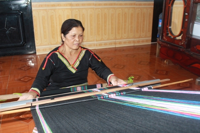 Bà H’Jih Ayun miệt mài bên khung dệt thổ cẩm.