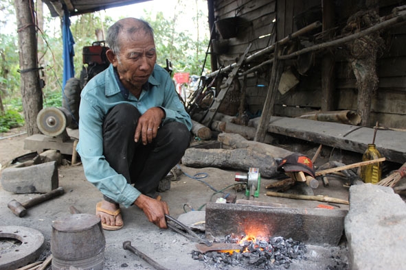 Cụ Y Ngoan đang rèn dao.