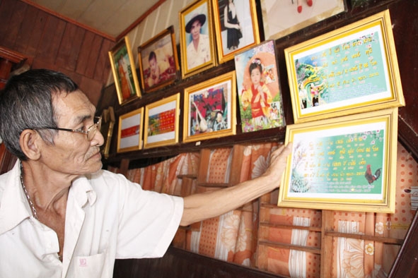 Nghệ nhân Tống Văn Thìn bên bảng chữ chúc mừng năm mới bằng tiếng Thái. 