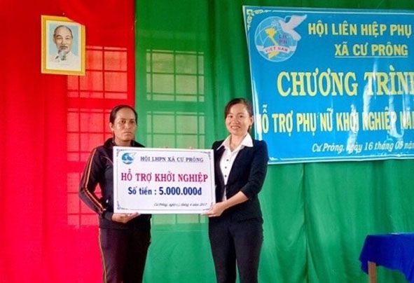 Hội Phụ nữ huyện Ea Kar trao vốn hỗ trợ khởi nghiệp cho chị H’Mai Niê (trái) ở thôn 15,  xã Cư Prông. 