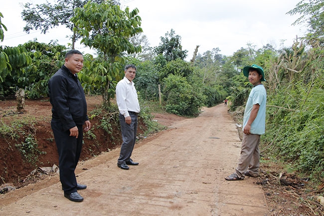 Cán bộ xã Tân Lập, huyện Krông Búk kiểm tra tuyến đường bê tông do nhân dân đóng góp xây dựng ở thôn Tân Thịnh.