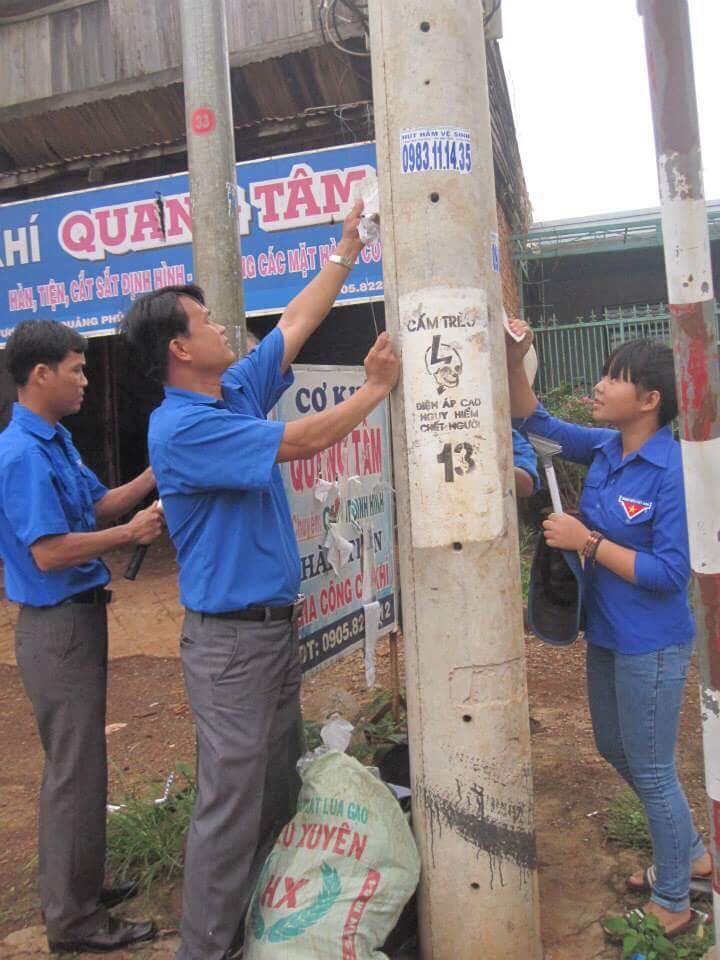 Đoàn viên thanh niên thị trấn Quảng Phú tham gia xóa quảng cáo trên cột điện. 
