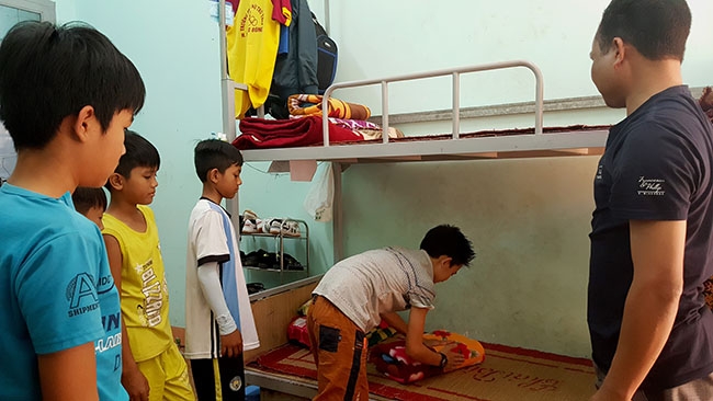 Cán bộ quản sinh Trường PTDTNT-THCS Krông Bông hướng dẫn học sinh  gấp chăn màn. 