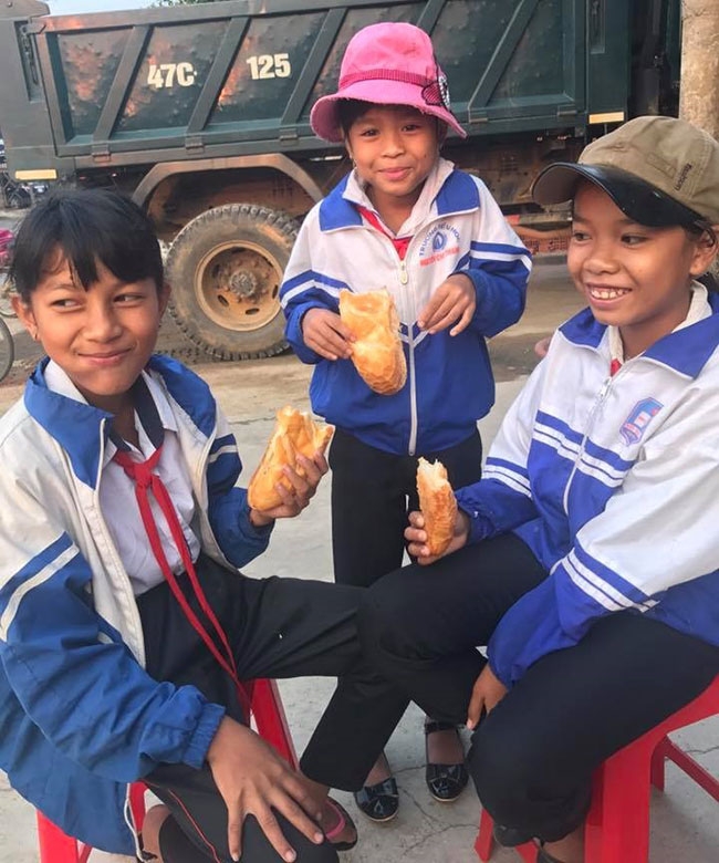 Các em học sinh đến ăn sáng tại tủ bánh. 