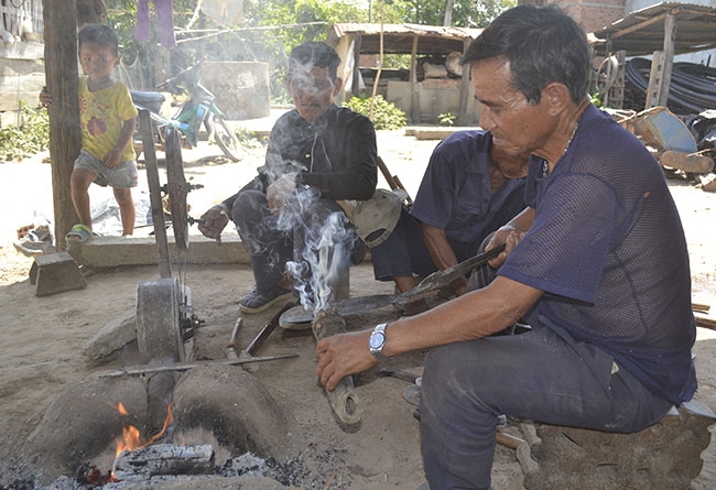 Thợ rèn dùng sừng trâu để mài dao.