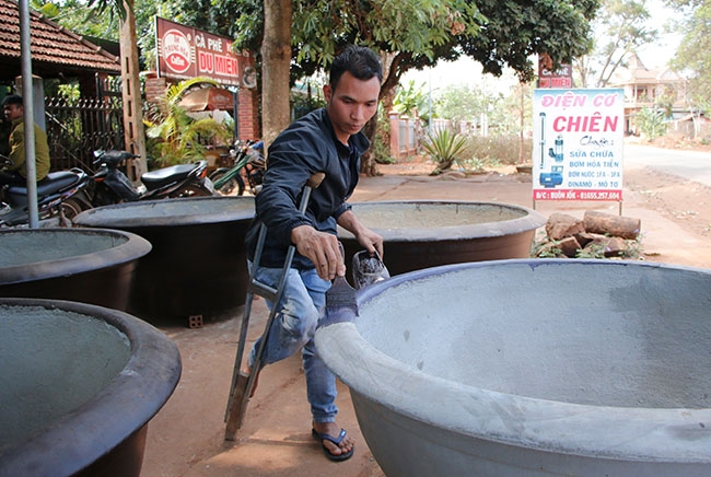 Anh  Y Phăng Mlô, trú tại  buôn Jok (xã Ea H’đing)  đang sơn  chậu cây cảnh trước khi bán.   