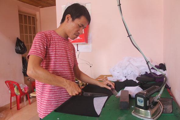 Người thợ may gia công tại nhà miệt mài làm việc để tăng thu nhập trang trải cuộc sống.