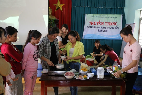 Cán bộ Trung tâm Chăm sóc sức khỏe sinh sản tỉnh hướng dẫn các bà mẹ nấu cháo dinh dưỡng cho trẻ. 