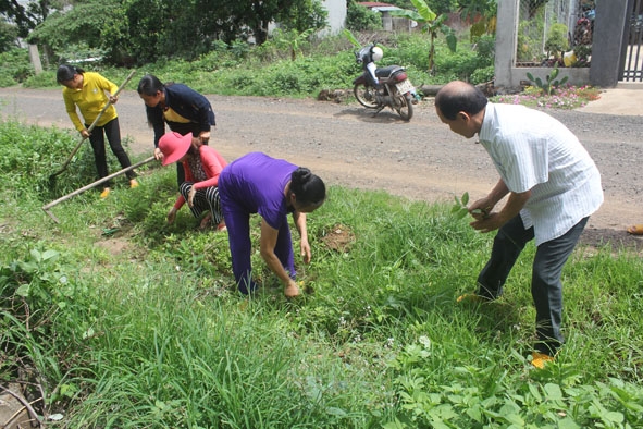 Người dân thôn 15  (xã Tân Hòa, huyện Buôn Đôn) đang dọn dẹp vệ sinh môi trường trên tuyến đường nội thôn. 