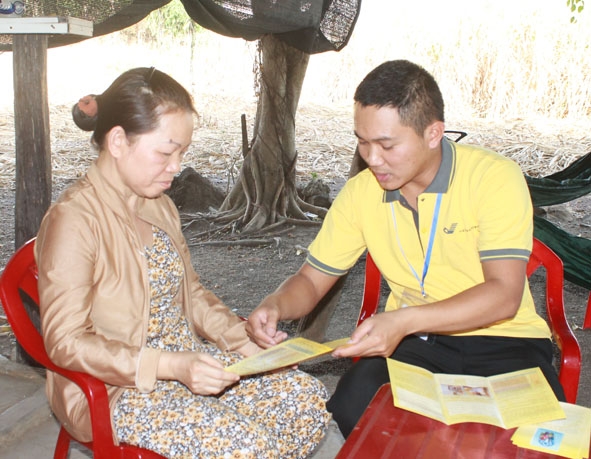 Nhân viên đại lý thu BHXH, BHYT huyện Buôn Đôn tuyên truyền cho người dân về chính sách BHYT.