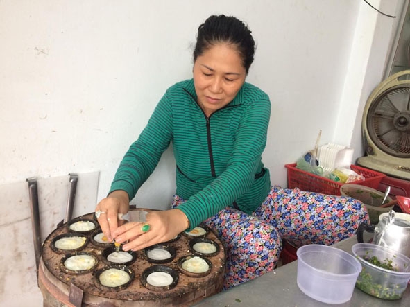 Chị Hồ Thị Liên đang làm bánh căn phục vụ khách.  