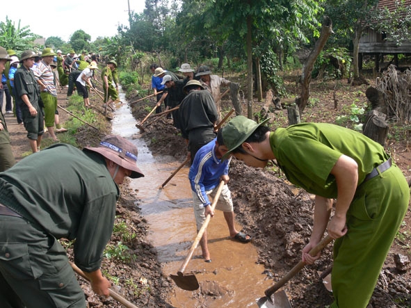 Đoàn viên, thanh niên Công an tỉnh giúp nhân dân nạo vét kênh mương.  