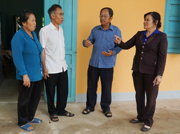 Bí thư Chi bộ thôn 3, xã Ea Tu Phạm Thị Huệ (bìa phải) trao đổi công việc  với cán bộ, đảng viên trong thôn.