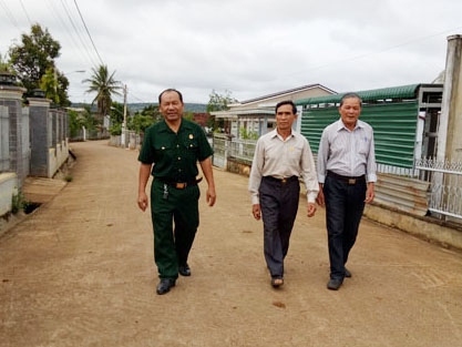Ông Ngạn (giữa) trên tuyến đường do ông đứng ra vận động mọi người trong khu phố đóng góp xây dựng. 